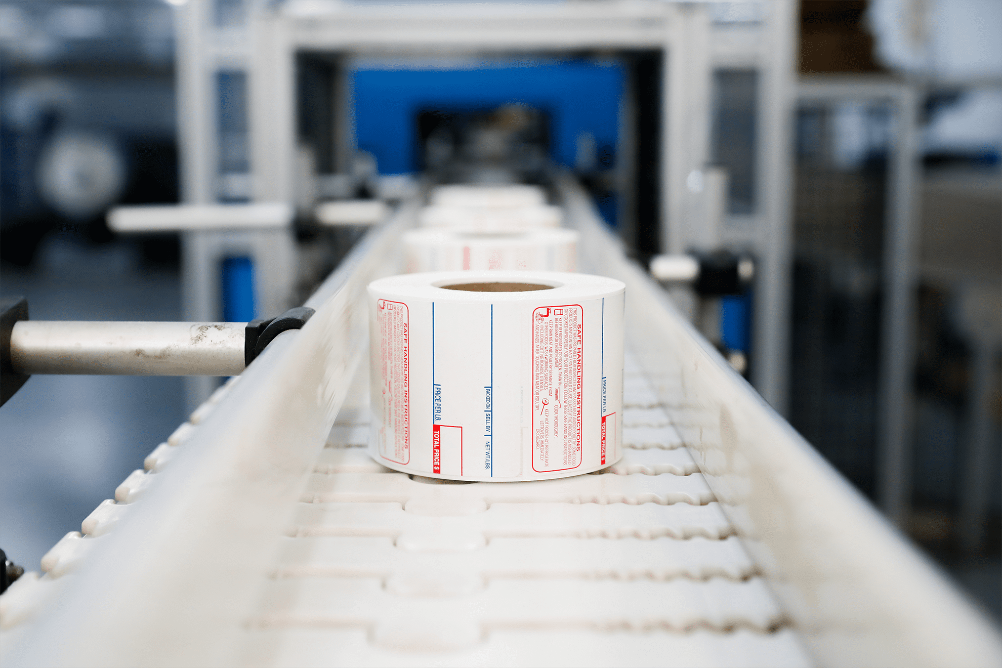 A roll of scale labels rolling down a conveyor belt