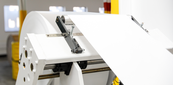 Label material rolloing across a machine