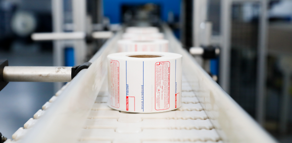 A roll of scale labels rolling down a conveyor