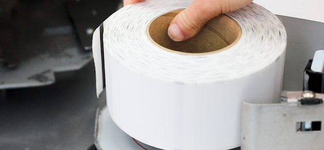 A roll of scale labels being placed into a machine
